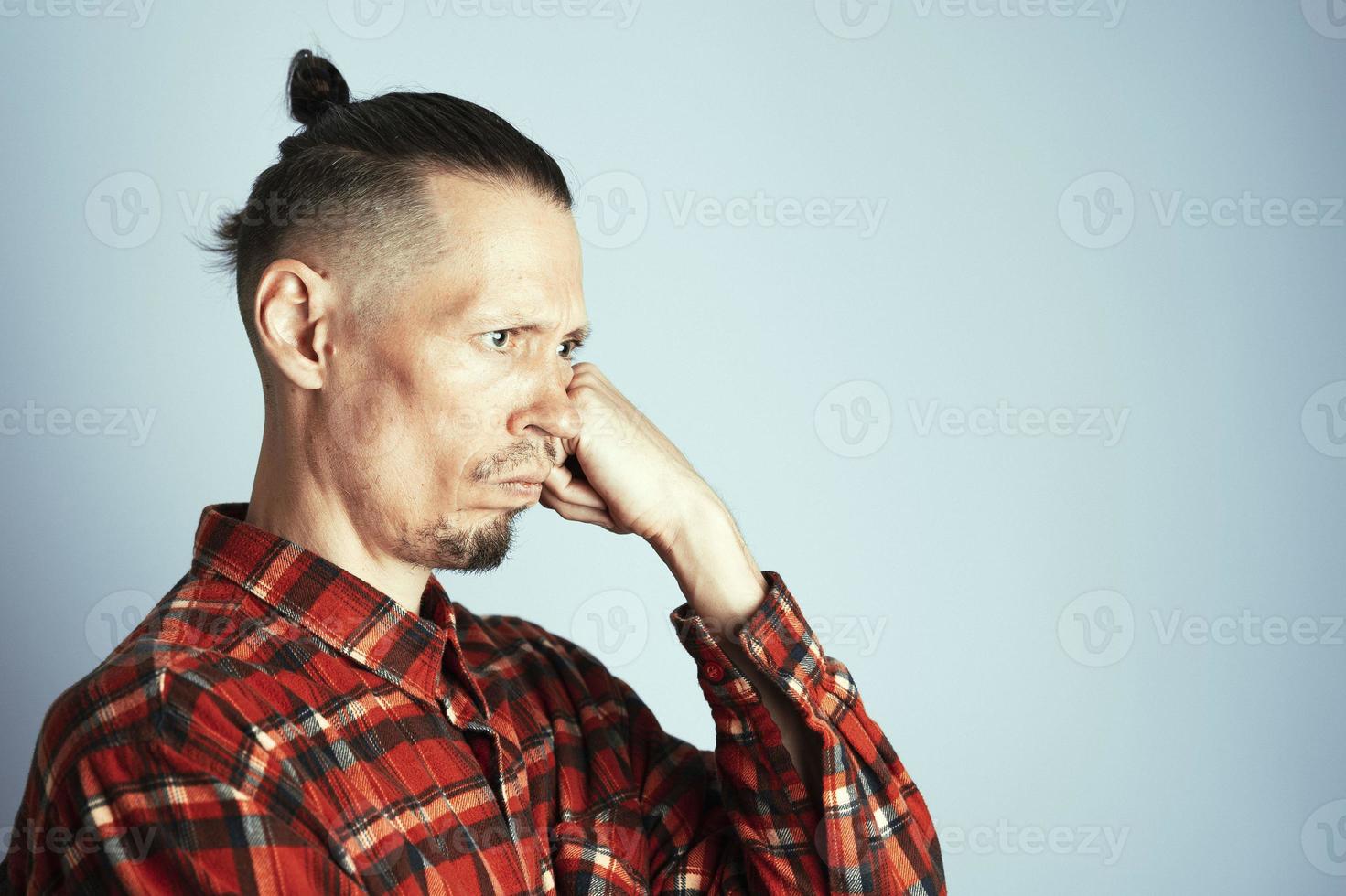 une fermer photo de une sérieusement réfléchi Jeune homme