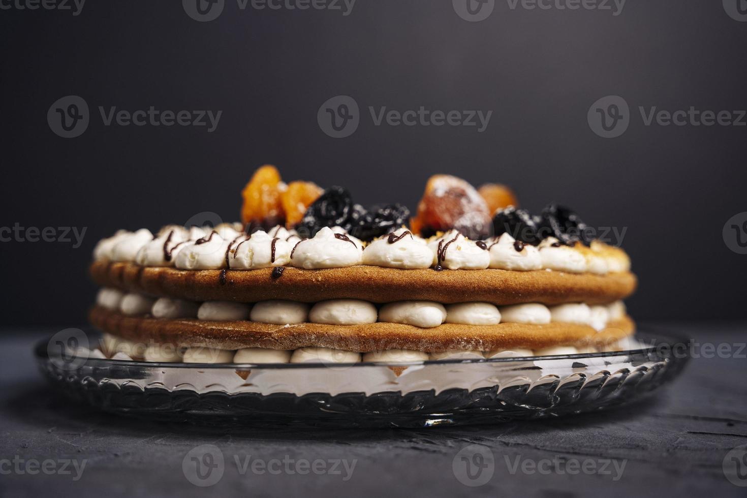 délicieux magnifique rond éponge en couches crème gâteau décoré avec pruneaux et séché abricots photo