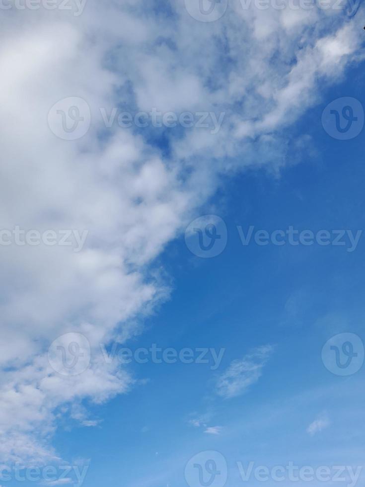 nuages blancs dans le ciel bleu. beau fond bleu clair. peu nuageux, beau temps. nuages bouclés par une journée ensoleillée. photo