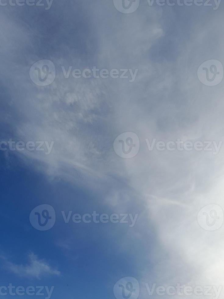 beaux nuages blancs sur fond de ciel bleu profond. de grands nuages doux et moelleux couvrent tout le ciel bleu. photo