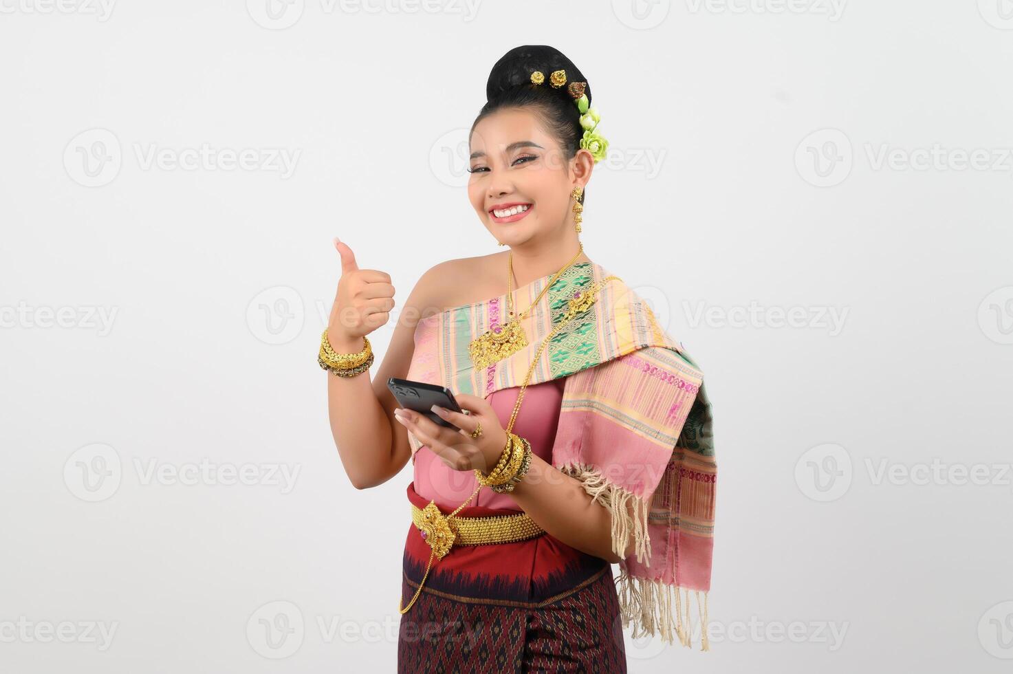 Jeune magnifique femme dans nord-est robe utilisation téléphone intelligent posture photo