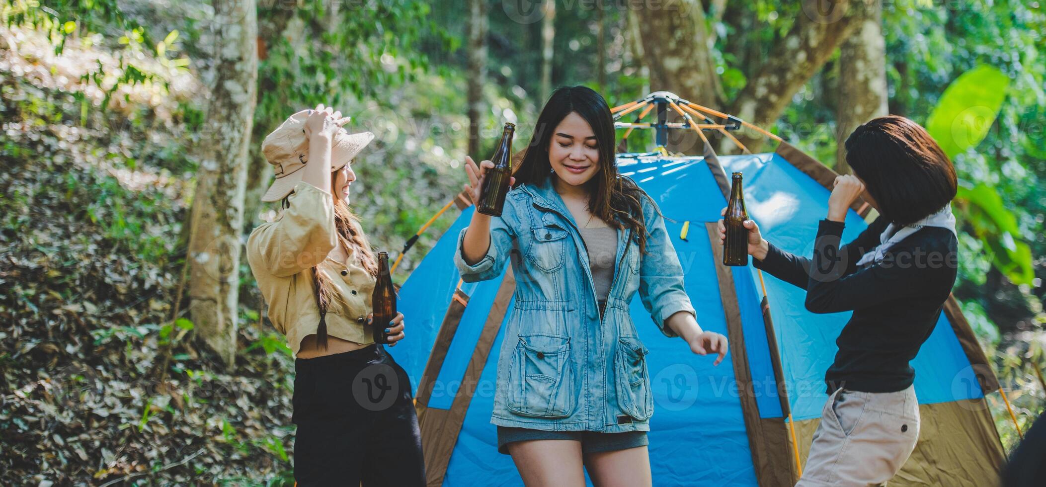 jeune femme applaudir et boire une boisson devant la tente de camping photo