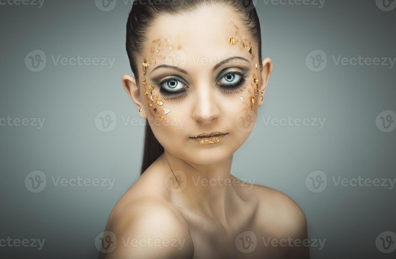 glamour portrait de Jeune magnifique fille avec gros bleu yeux, luxuriant cils et brillant d'or maquillage photo