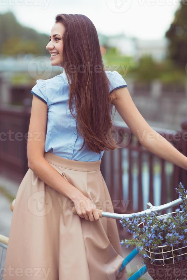 belle jeune femme élégamment vêtue avec vélo photo