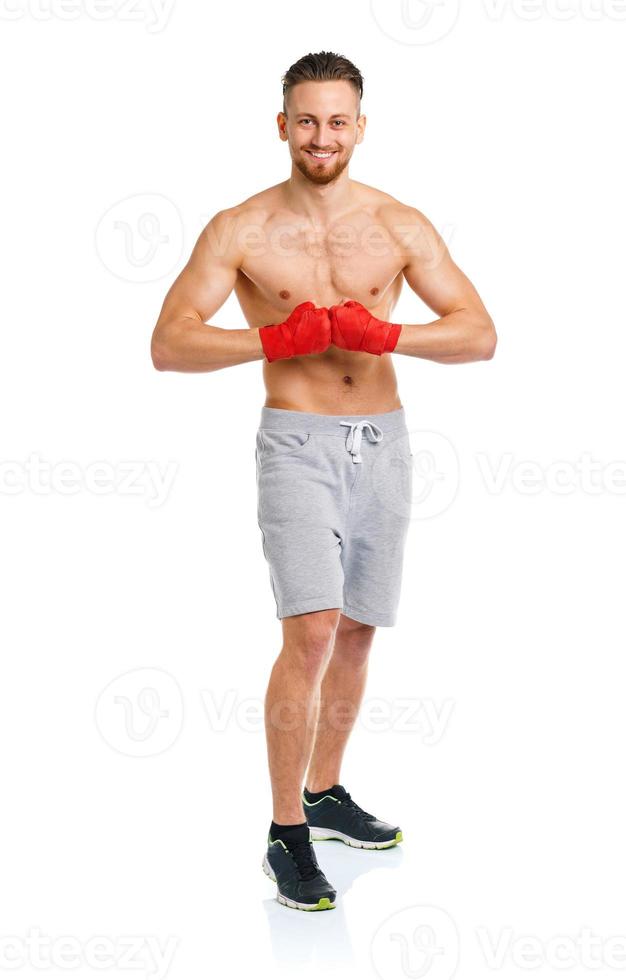 Homme séduisant athlétique portant des bandages de boxe sur le blanc photo