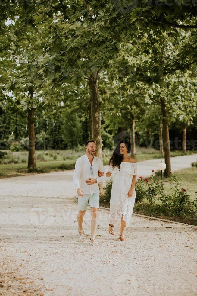 une content Jeune couple est profiter le magnifique alentours de une jardin, se prélasser dans le Soleil et chaque autres entreprise photo