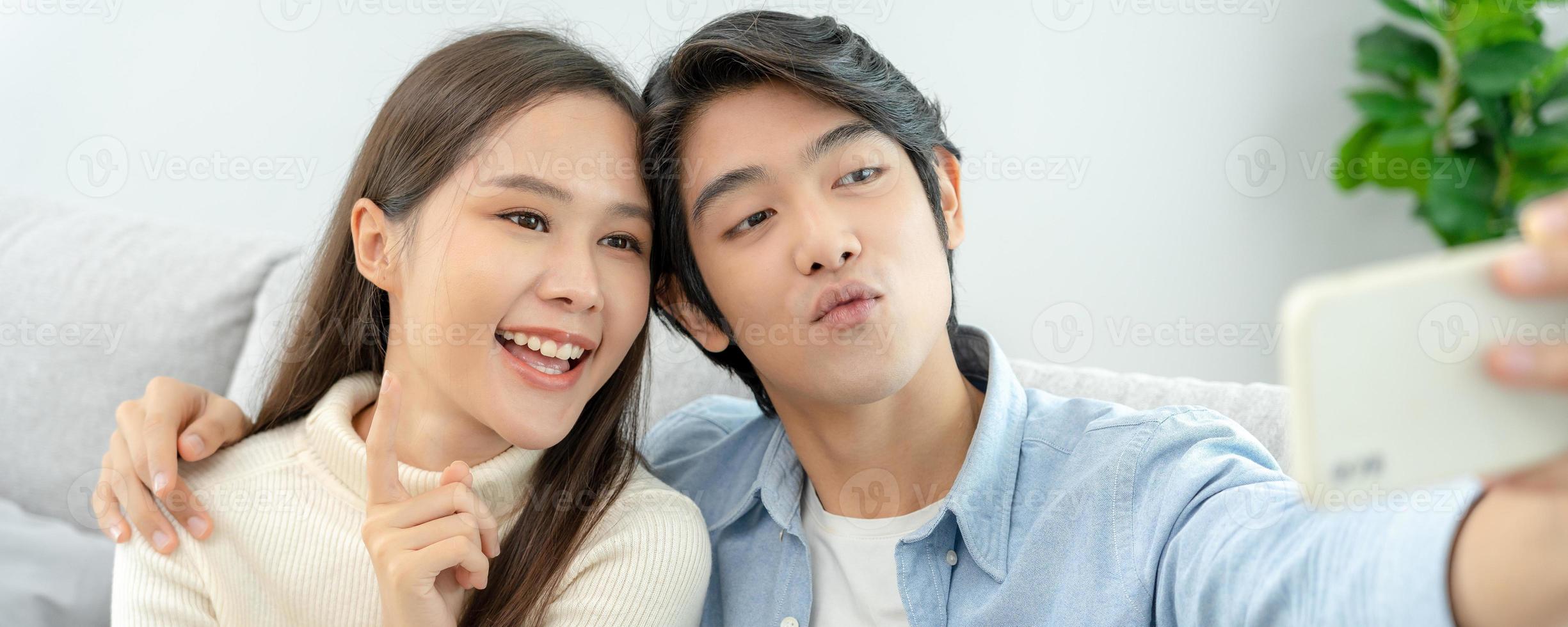 les couples asiatiques profitent d'une nouvelle maison et prennent des selfies ensemble. mari et femme adolescents après le mariage. bonheur et sourires et rires en famille chaleureuse. câlins, câlins chaleureux, premier amour d'adolescent photo