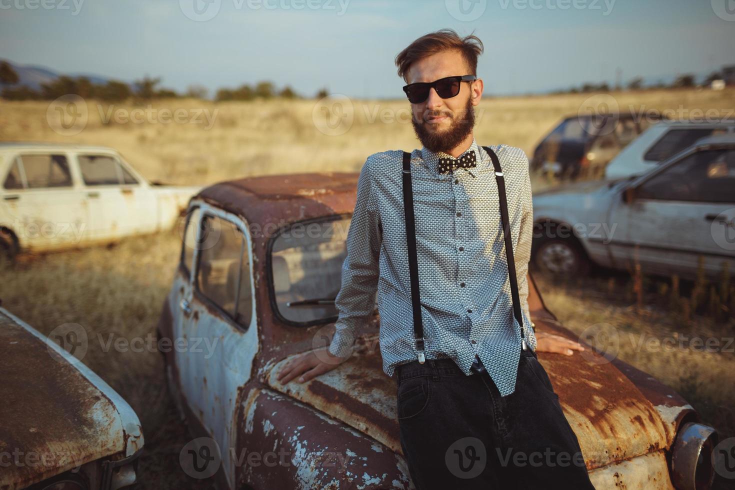 Jeune Beau élégant homme, portant chemise et nœud papillon avec vieux voitures photo