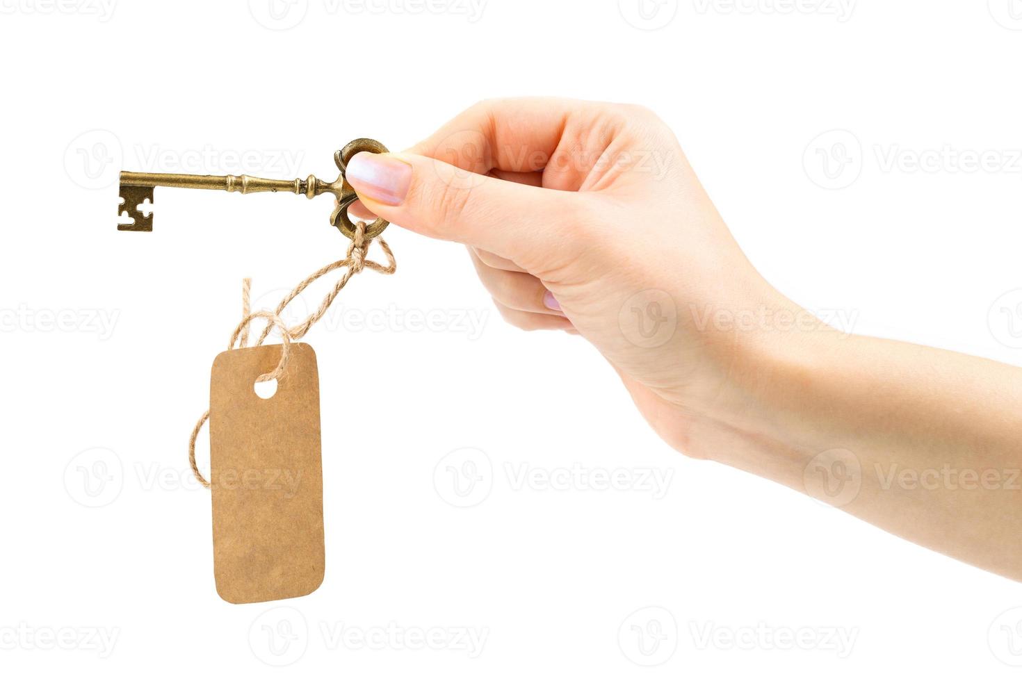 ancien clé avec une étiquette dans une femelle main photo