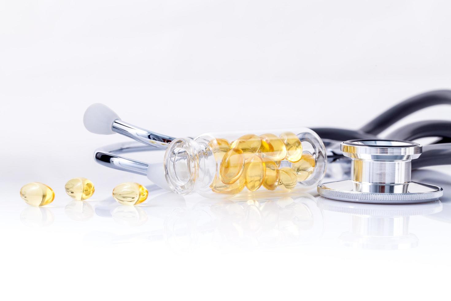 Pilules d'huile de poisson et un stéthoscope sur blanc photo