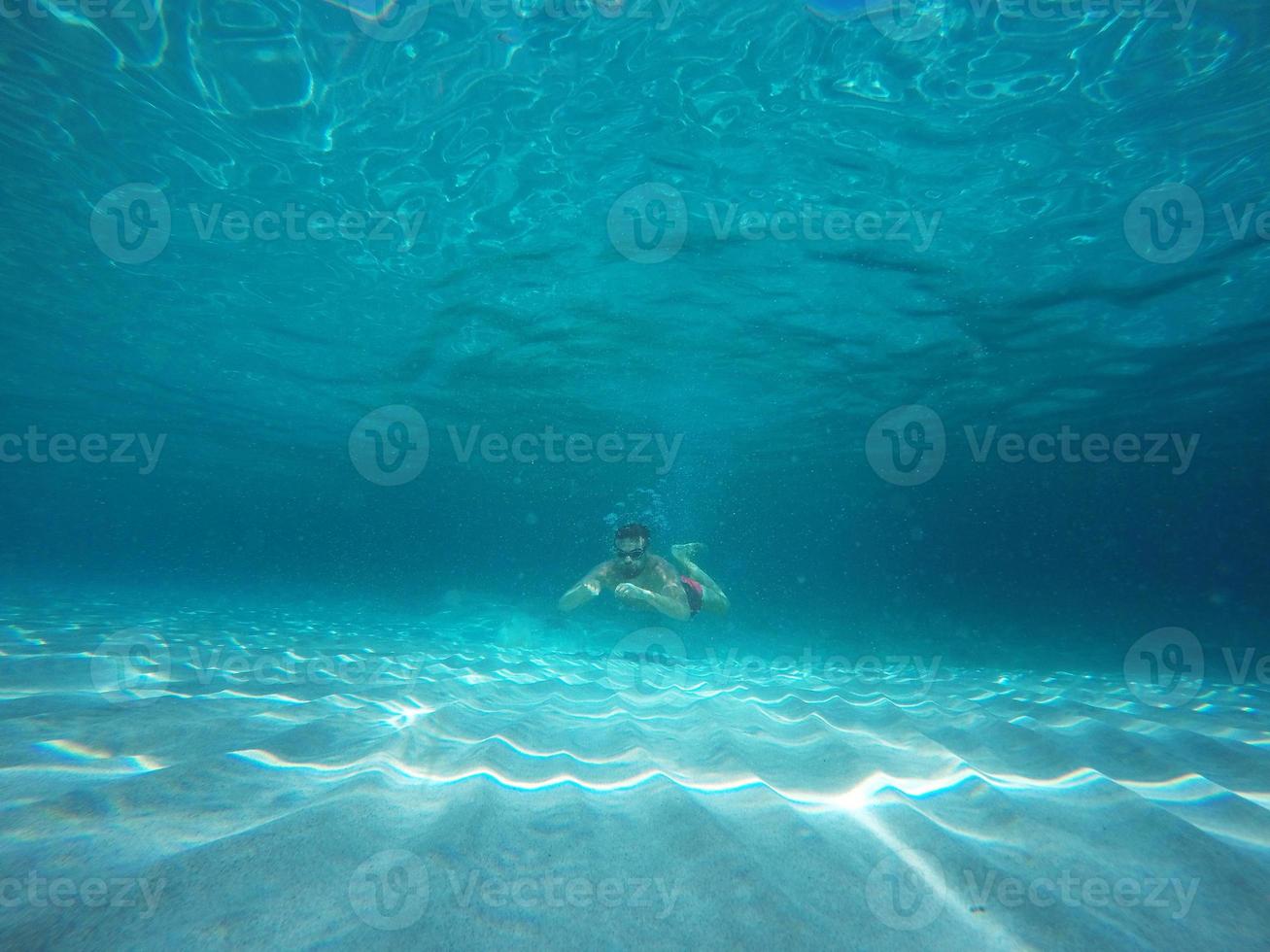 barbe homme avec des lunettes plongée dans une bleu nettoyer l'eau photo