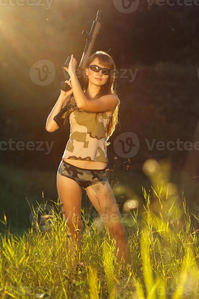 Jeune magnifique fille avec une fusil à pompe dans un Extérieur photo