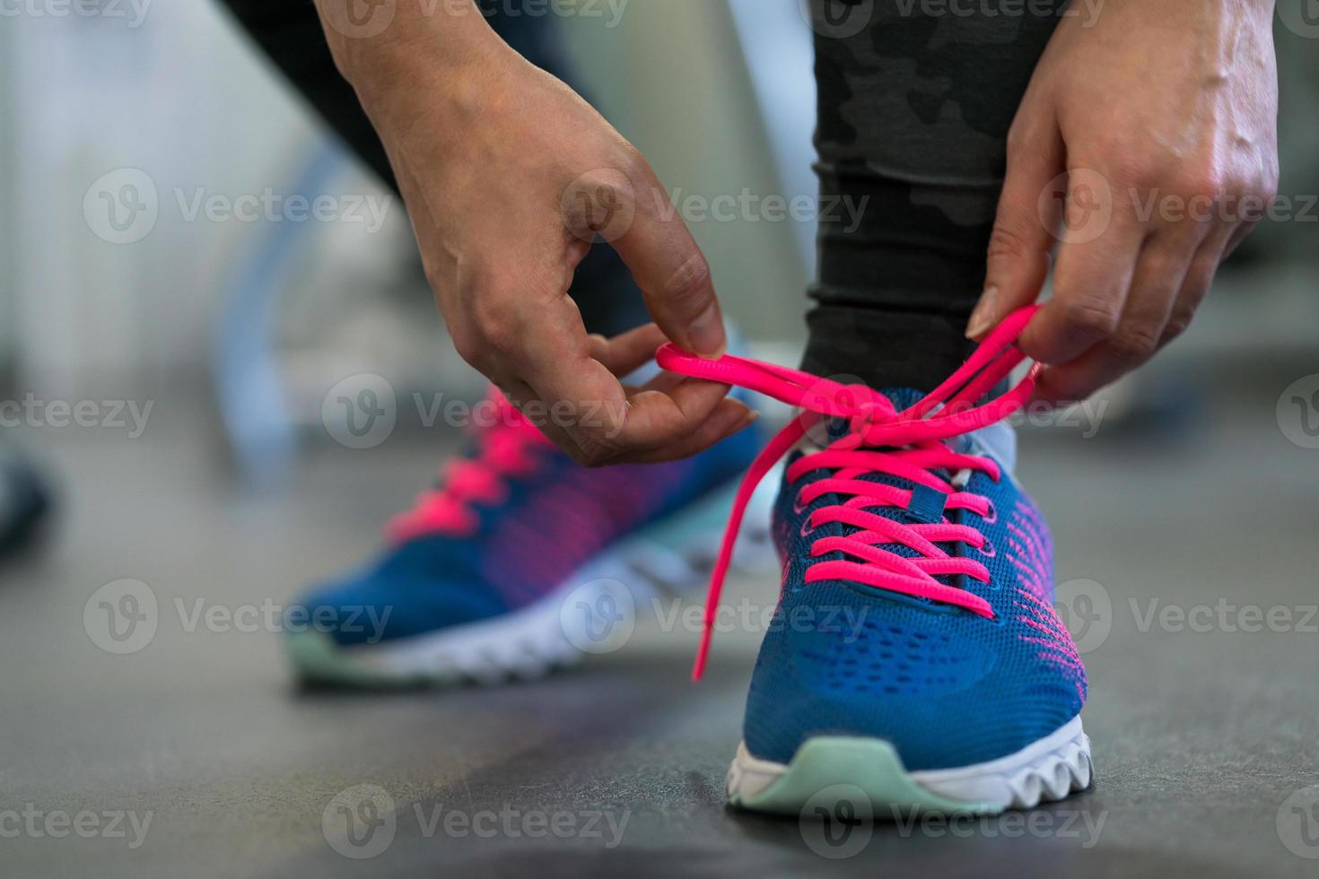 fonctionnement des chaussures - femme attacher chaussure lacets. femme avoir prêt pour engager dans le Gym photo