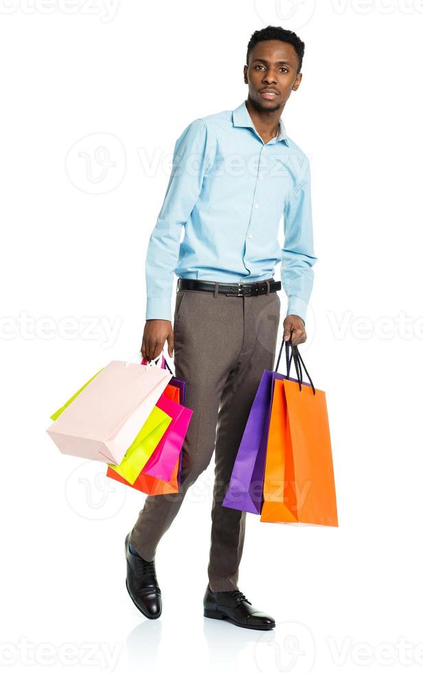 africain américain homme en portant achats Sacs sur blanc Contexte. achats photo