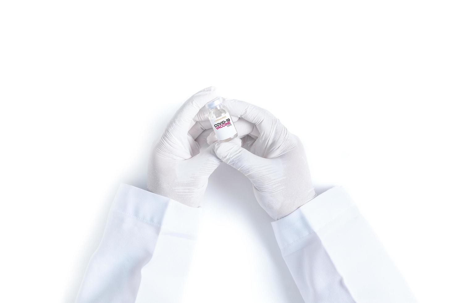 médecin ou scientifique main dans blanc gants en portant covid-19 vaccin photo