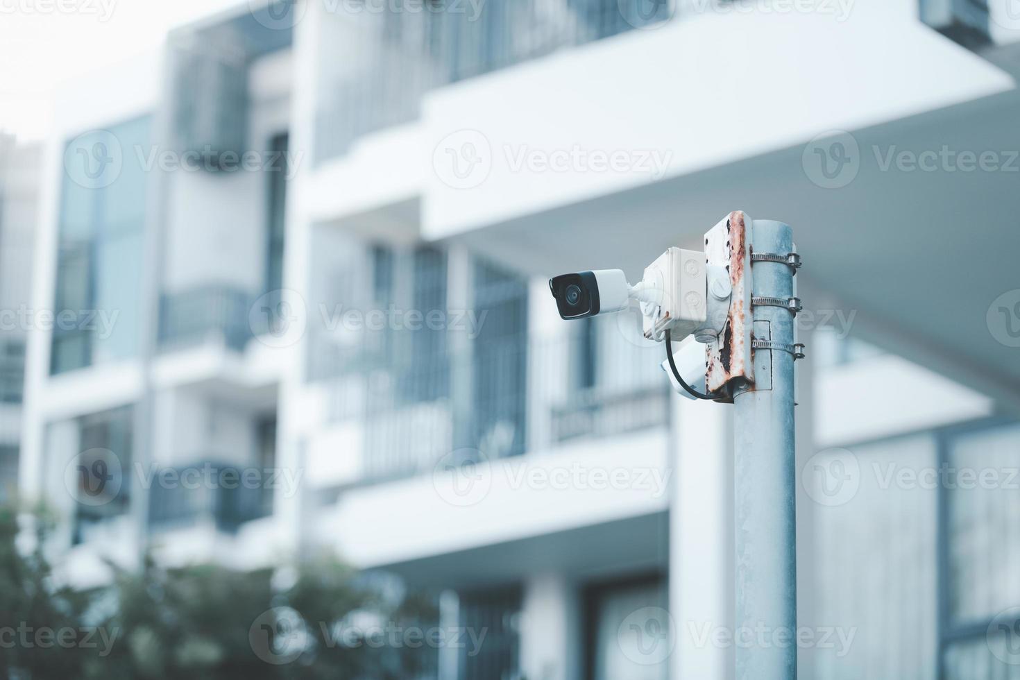 vidéosurveillance. vidéo surveillance caméra est monté sur une pôle à l'extérieur un appartement bâtiment. photo