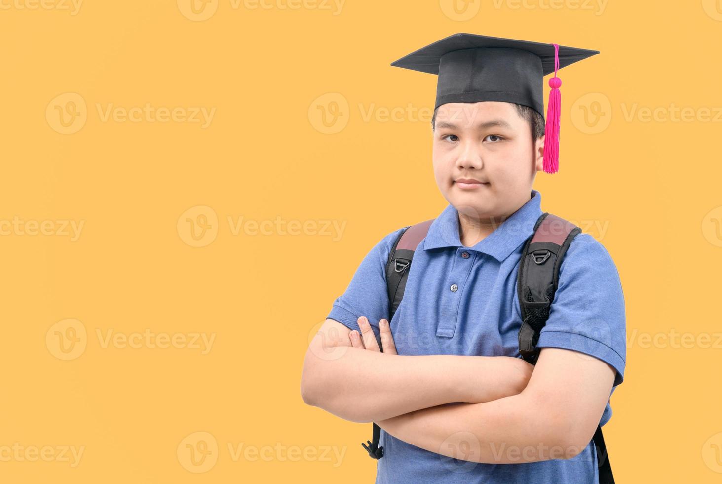 intelligent asiatique étudiant porter l'obtention du diplôme casquette et franchi bras. photo