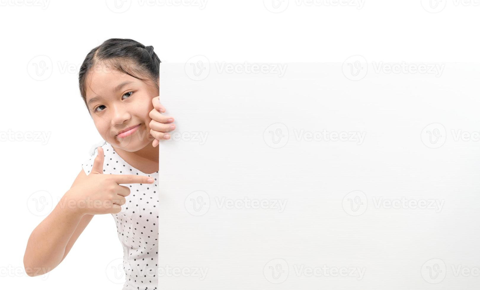 mignonne peu fille montrer du doigt Vide panneau d'affichage isolé sur blanc arrière-plan, photo