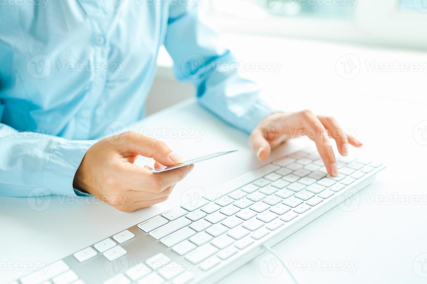 femelle mains en utilisant ordinateur et crédit carte sur il photo