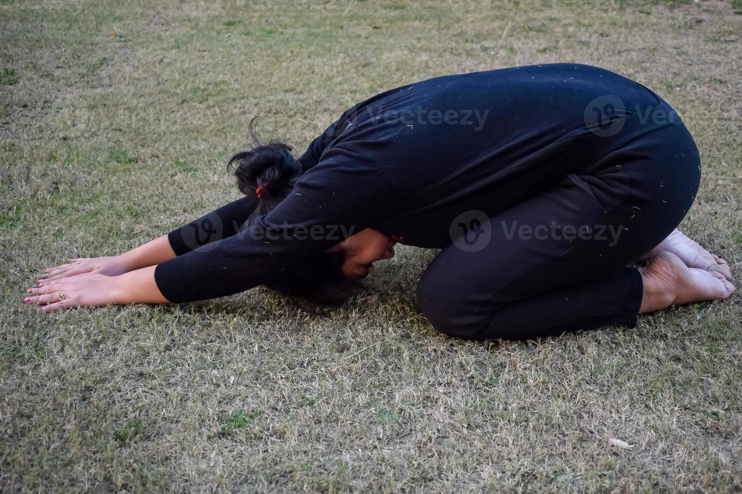 jeune femme indienne pratiquant le yoga en plein air dans un parc. belle fille pratique la pose de yoga de base. calme et détente, bonheur féminin. poses de yoga de base en plein air photo