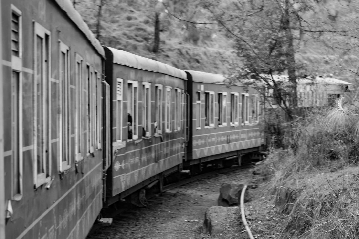 petit train se déplaçant sur les pentes de la montagne, belle vue, un côté montagne, un côté vallée se déplaçant sur le chemin de fer jusqu'à la colline, parmi la forêt naturelle verdoyante. train jouet de kalka à shimla en inde, train indien photo