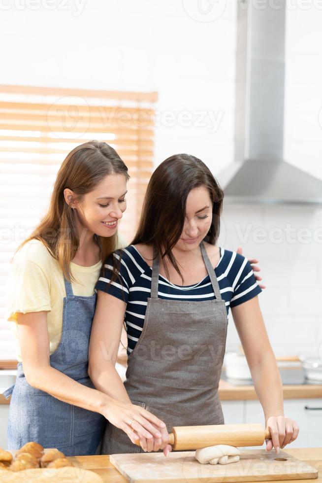 deux caucasien femmes cuisine Pizza ensemble dans le cuisine. le concept de fait maison nourriture et lgbt des relations. famille et la diversité concept. lgbt. photo