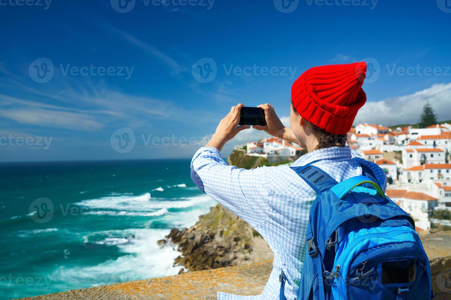 femme avec une sac à dos fait du une photo sur le téléphone intelligent de une magnifique panorama