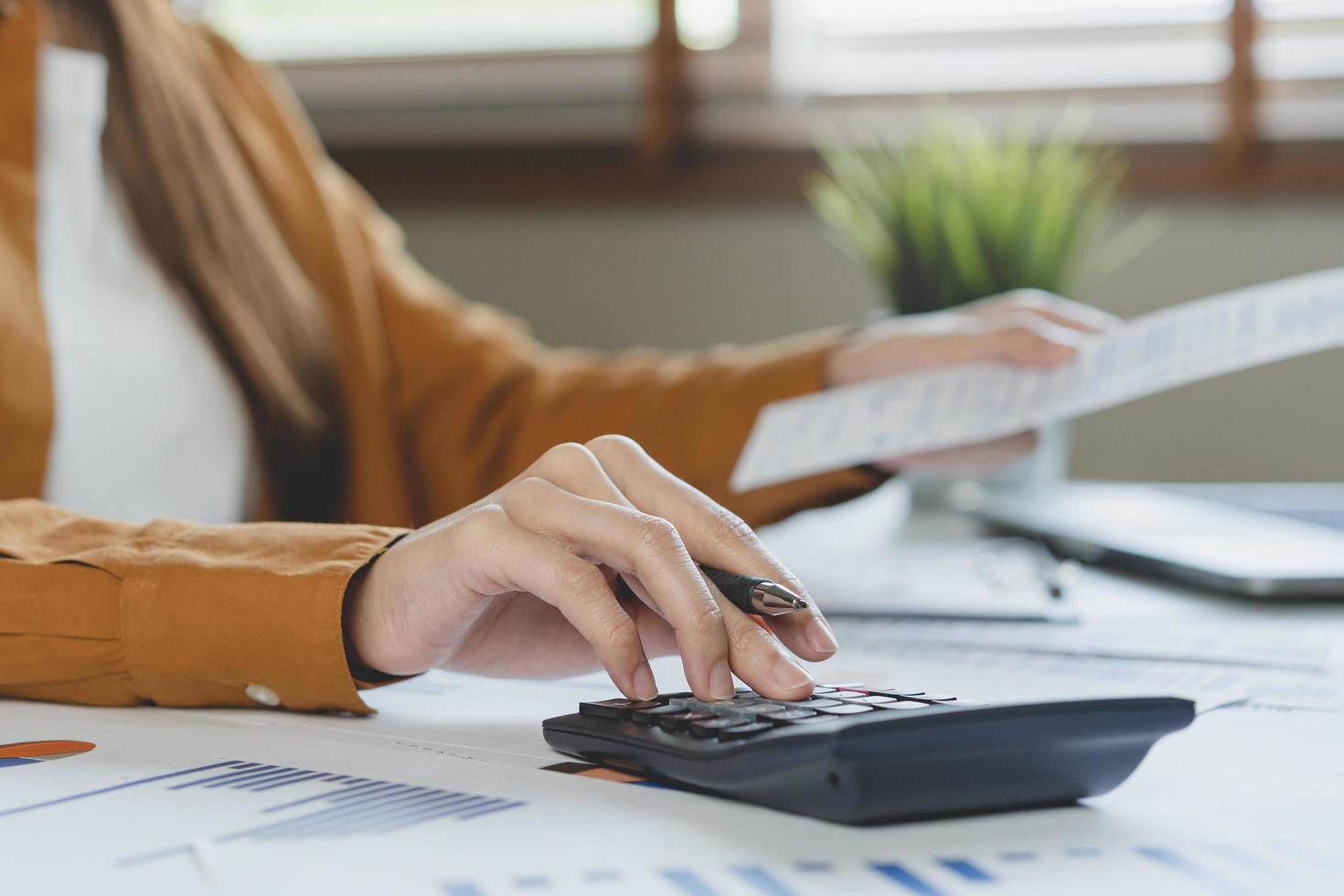 proche en haut main de stress asiatique Jeune employé affaires femme calculer impôt le revenu et dépenses, factures, crédit carte pour Paiement ou jour de paie sur table à Accueil bureau. financier, la finance gens concept. photo