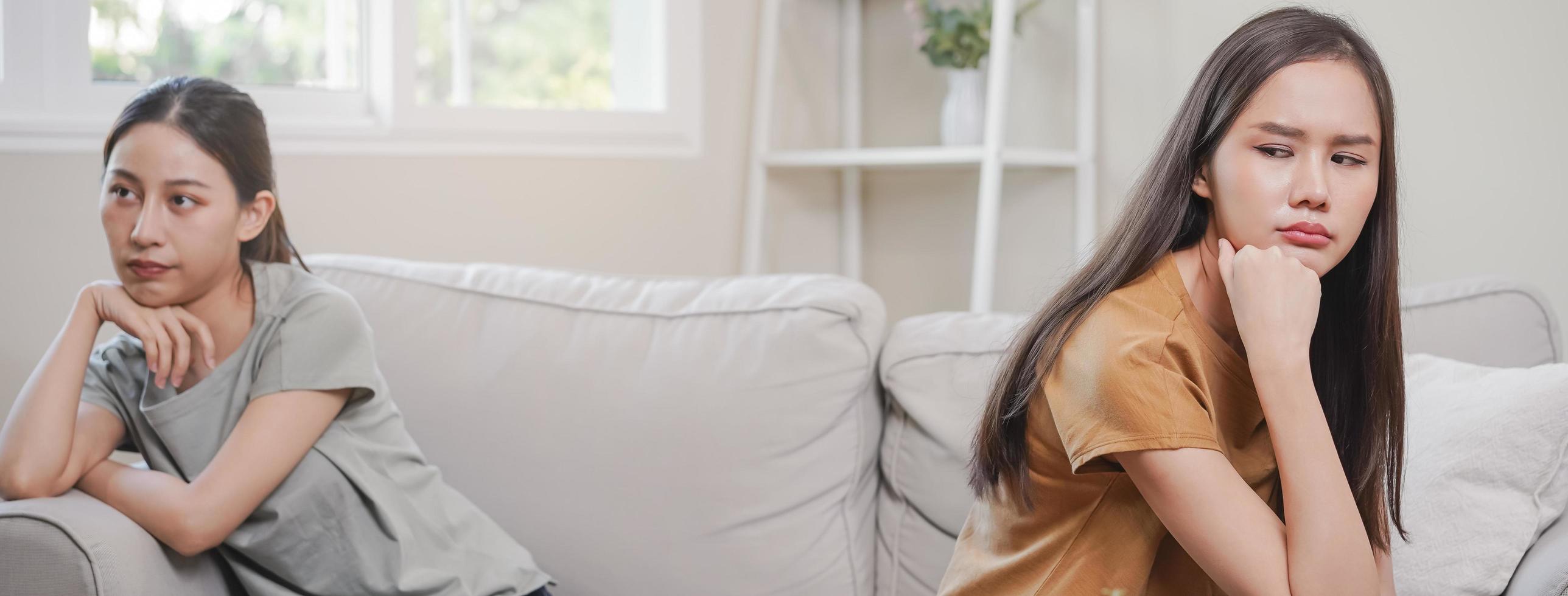 malheureux lesbienne, lgbt asiatique Jeune deux femmes, fille gay, couple l'amour bats toi sur canapé, relation est dans inquiéter. différent gens sont en colère et utilisation émotions à chaque autre, expression de déceptions. photo