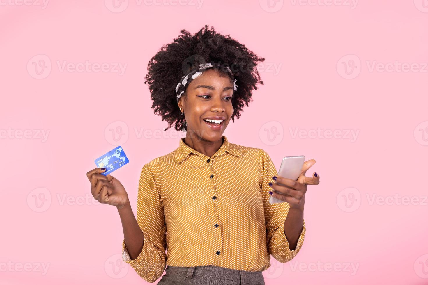 portrait de une africain américain femme permanent sur une rose Contexte en portant téléphone intelligent et argent, remise en argent. femme en portant argent et payant en ligne sur sa mobile téléphone photo