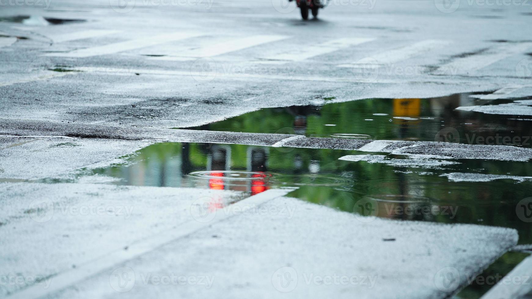 le peu l'eau bassin sur le route dans le ville après le pluie photo