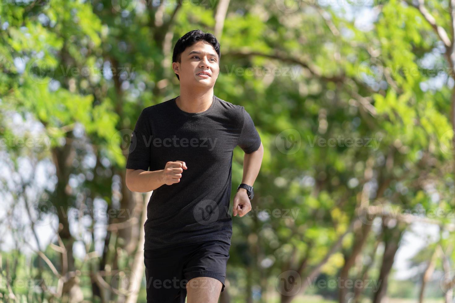 Masculin coureur le jogging dans le parc. il des exercices chaque Matin. photo
