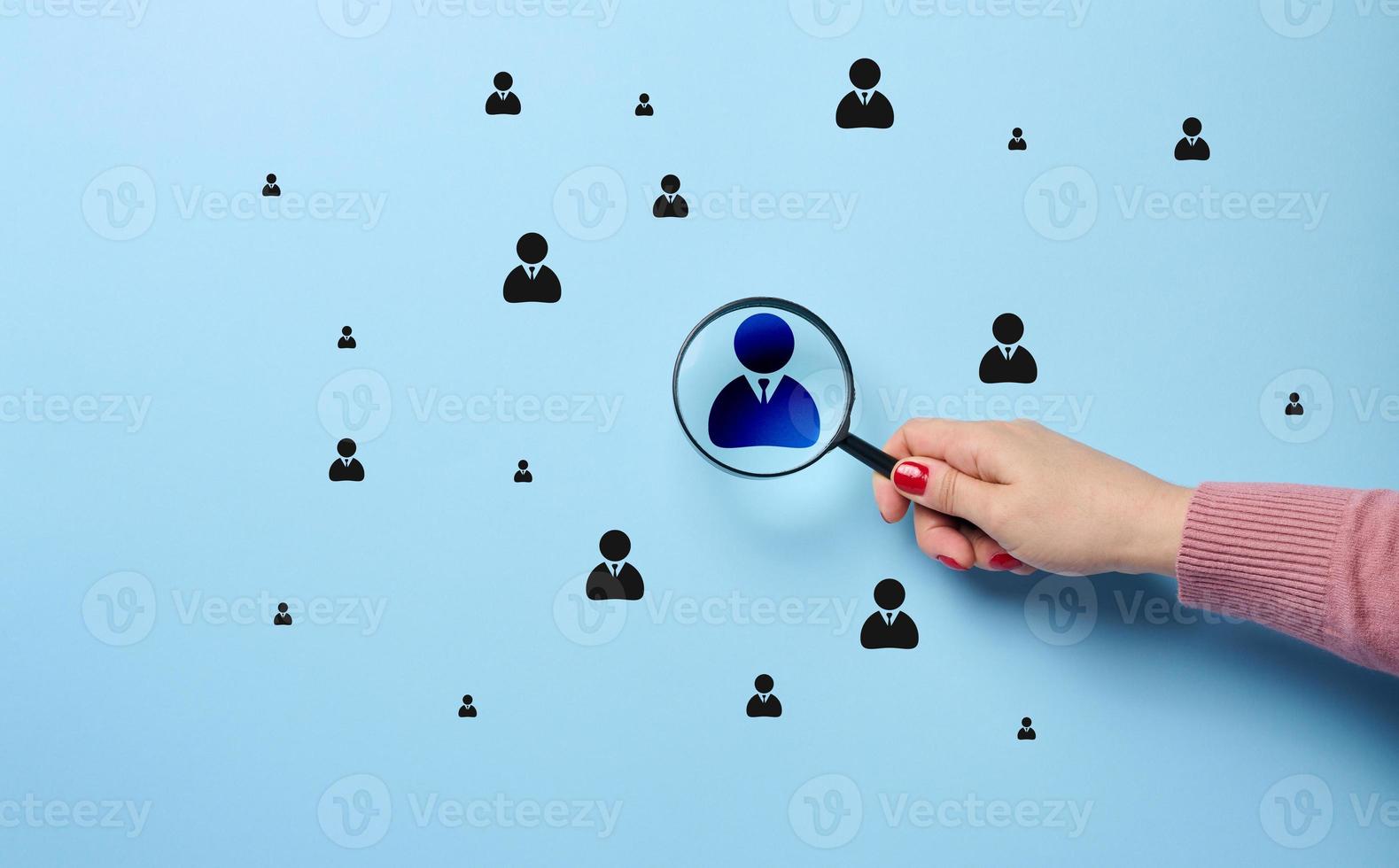 une femme main détient une grossissant verre et se concentre sur une direction badge, le concept de Humain Ressource la gestion photo