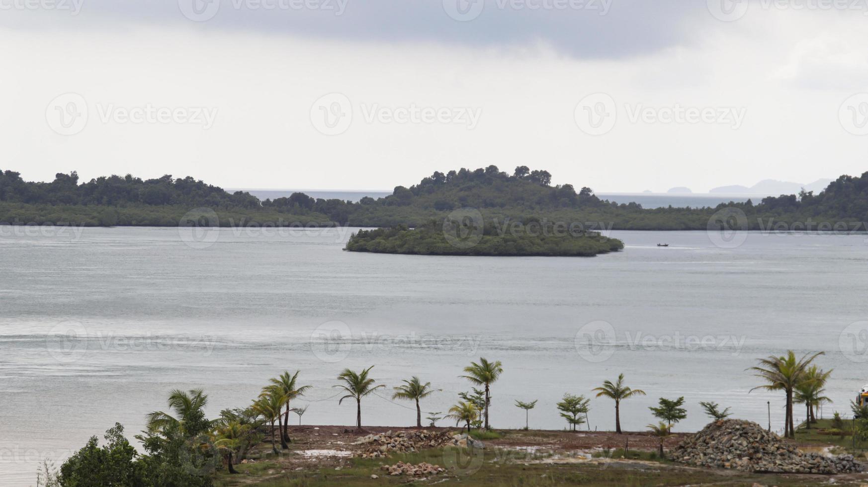 une petit port et le île à travers et le Contexte de le terre est trop développé avec des arbres. photo