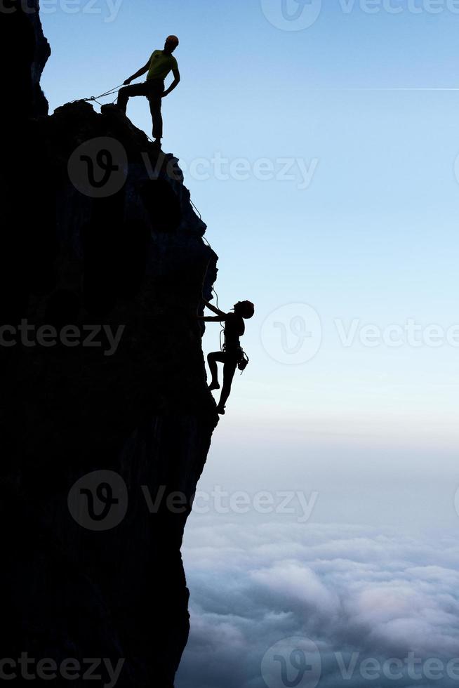 travail d & # 39; équipe d & # 39; un couple de grimpeurs en silhouette photo
