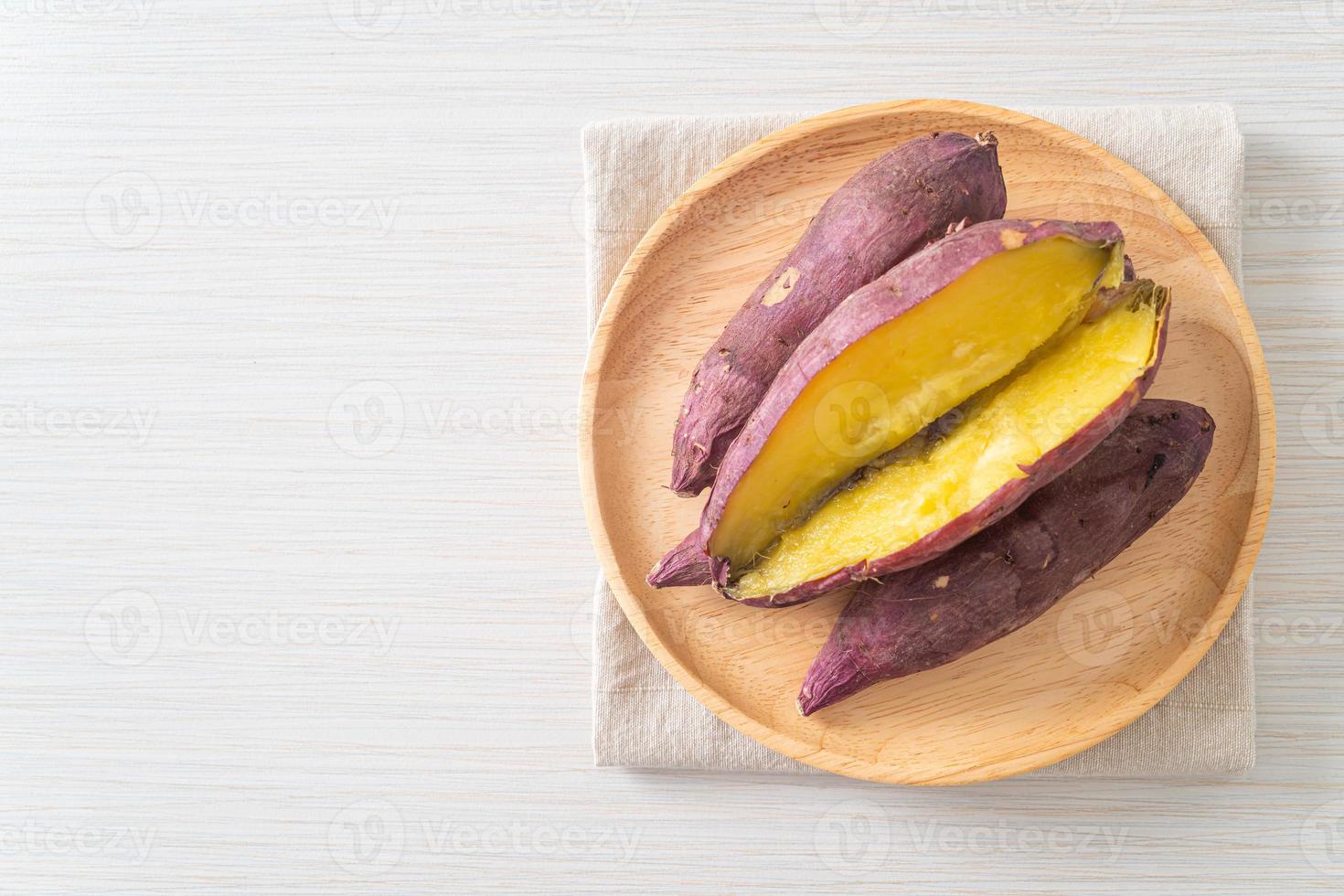 Patates douces japonaises grillées ou cuites au four sur plaque de bois photo