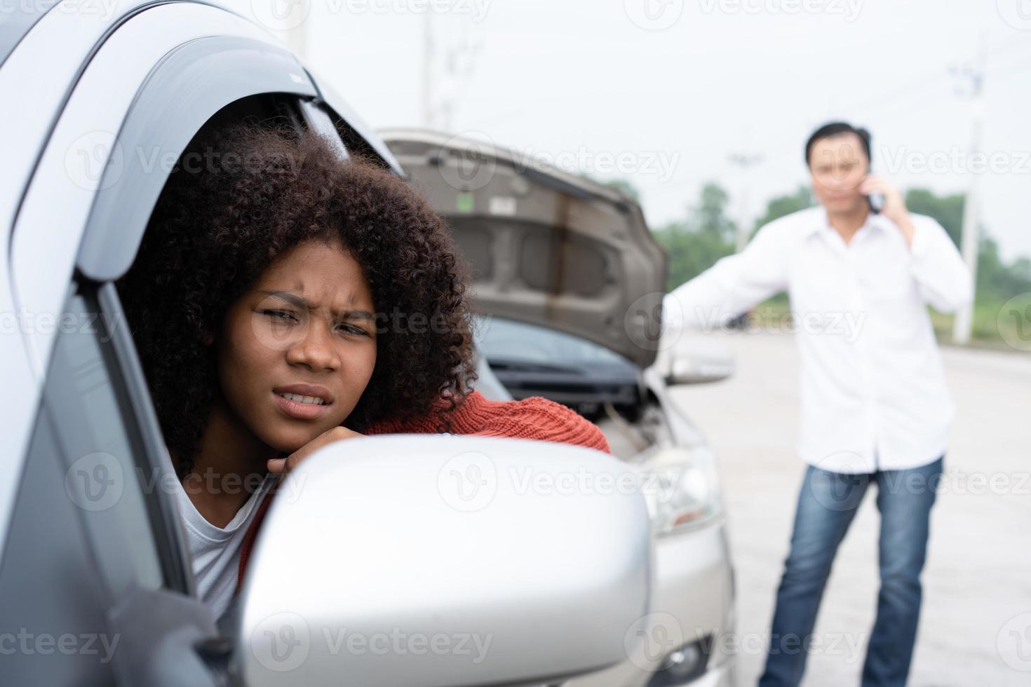 asiatique femmes Conducteurs asseoir dans voiture pour attendre Assurance après vérifier pour dommage après voiture accident, prise des photos à envoyer assurance. en ligne voiture accident Assurance prétendre après envoyer Photos à assurance.