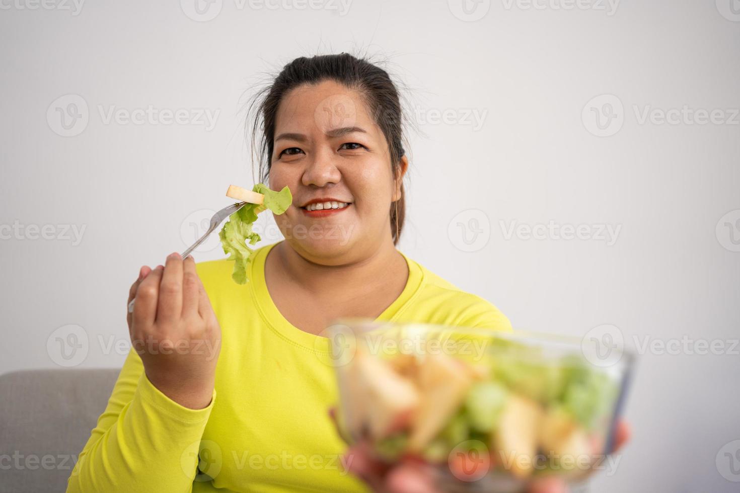 les enceintes asiatiques apprennent à cuisiner des repas sains à partir d'internet dans la cuisine, les grosses femmes préparent une salade de légumes pour les aliments diététiques et perdent du poids. concept d'alimentation saine photo