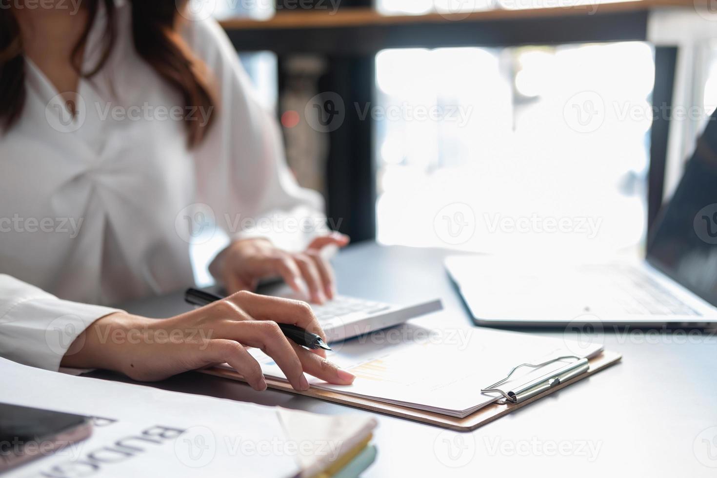 le marketing, la finance, la comptabilité, la planification, les femmes d'affaires analysent les résultats et les bénéfices de l'entreprise avec des statistiques graphiques. utiliser un ordinateur portable et une calculatrice pour calculer le solde de l'entreprise. photo