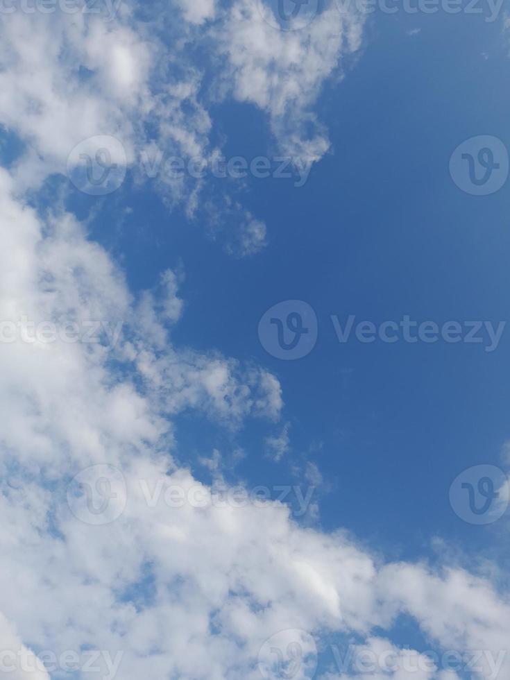 beaux nuages blancs sur fond de ciel bleu profond. de grands nuages doux et moelleux couvrent tout le ciel bleu. photo