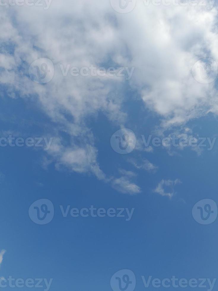 beaux nuages blancs sur fond de ciel bleu profond. de grands nuages doux et moelleux couvrent tout le ciel bleu. photo