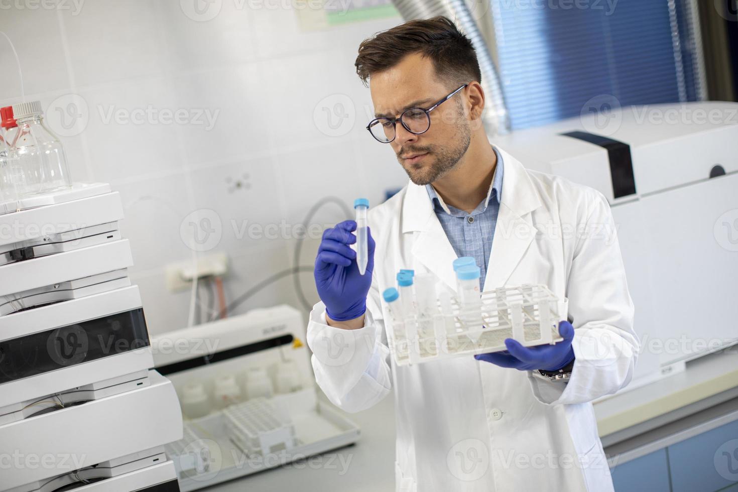 jeune chercheur travaillant avec des échantillons chimiques en laboratoire photo
