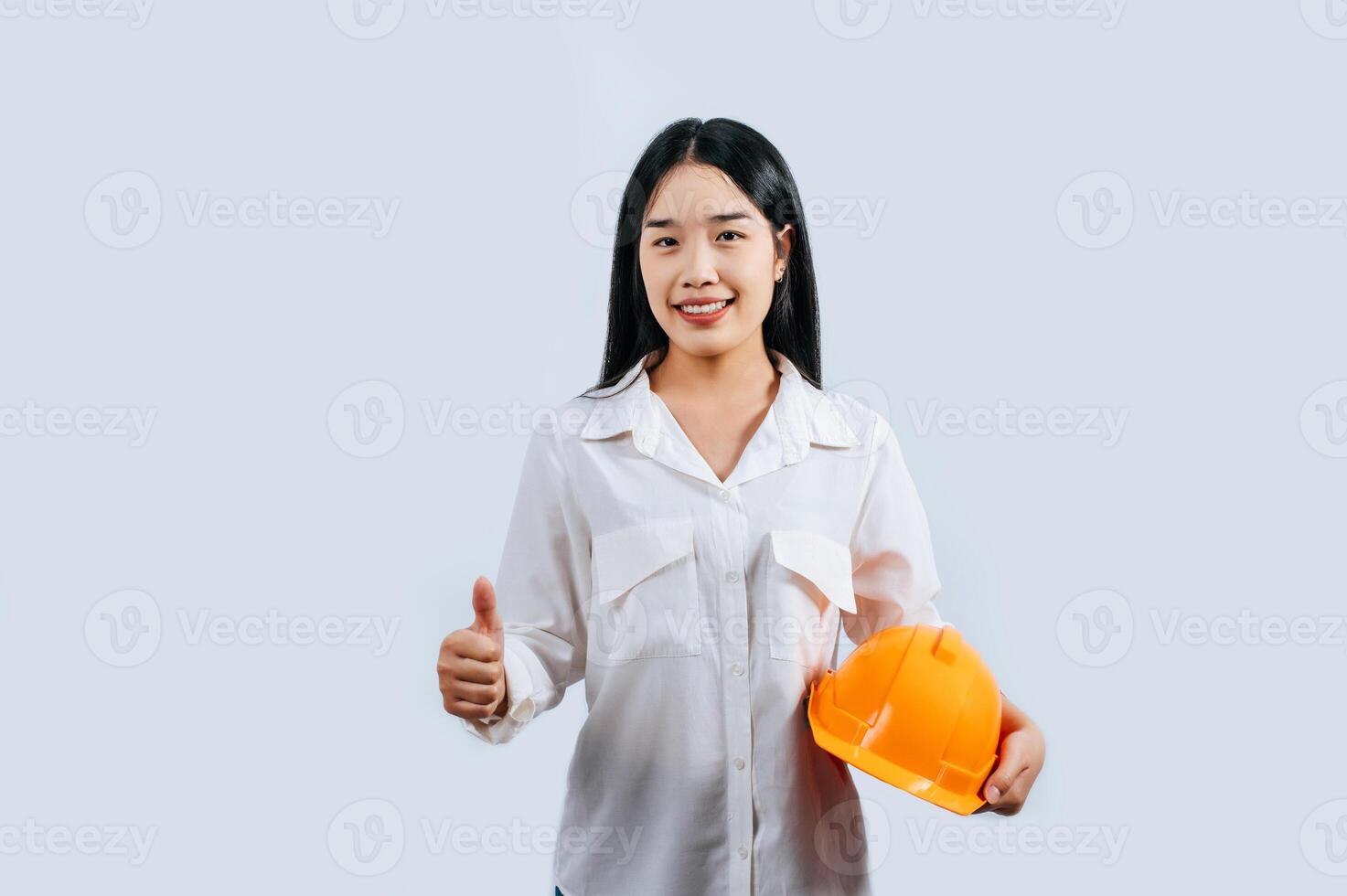Jeune femelle ingénieur dans casque supporter avec pouce en haut posture photo