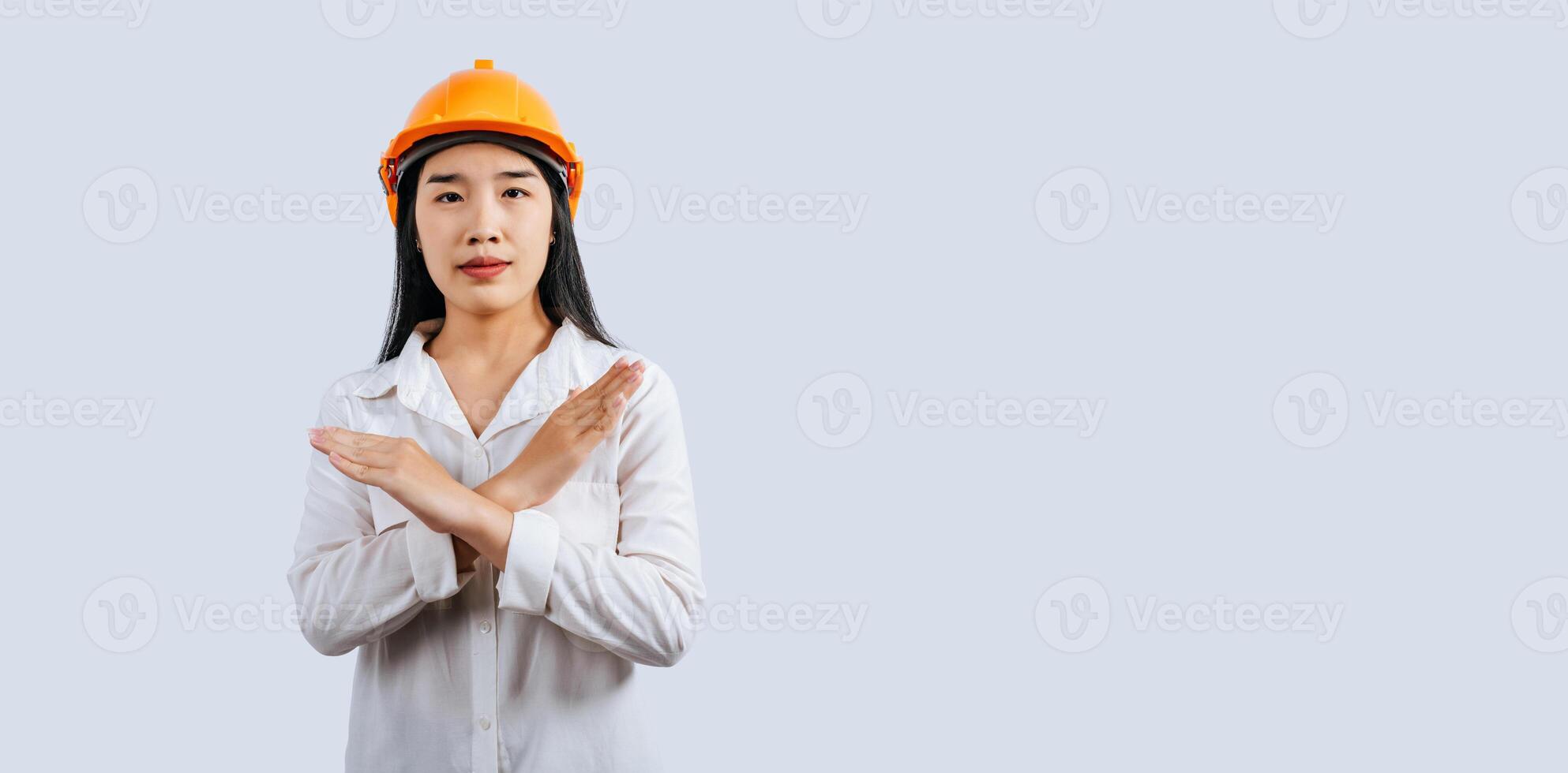 Jeune femelle ingénieur dans casque supporter avec Arrêtez signe posture photo