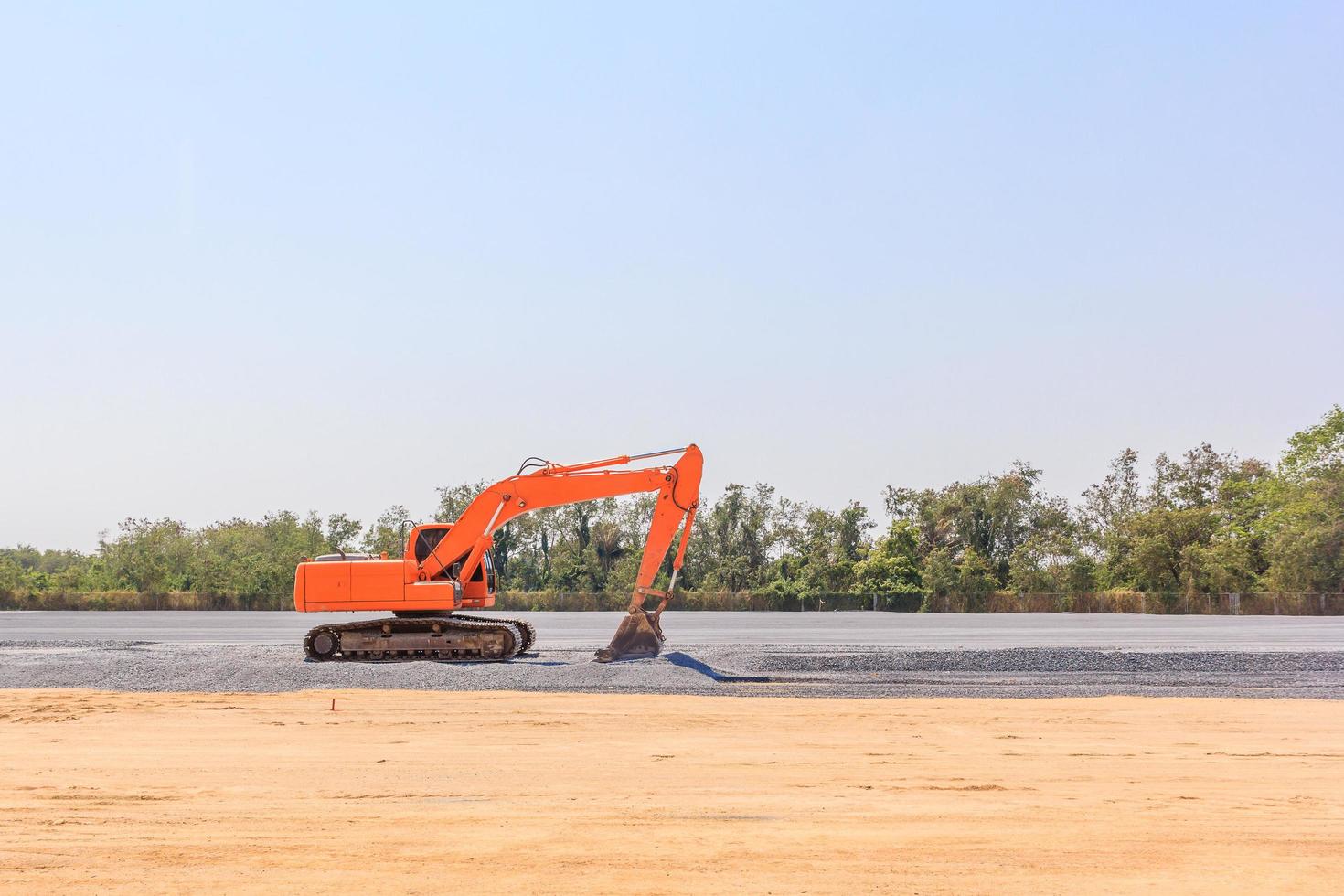 Excavatrice sur un chantier de construction sur fond de ciel bleu photo