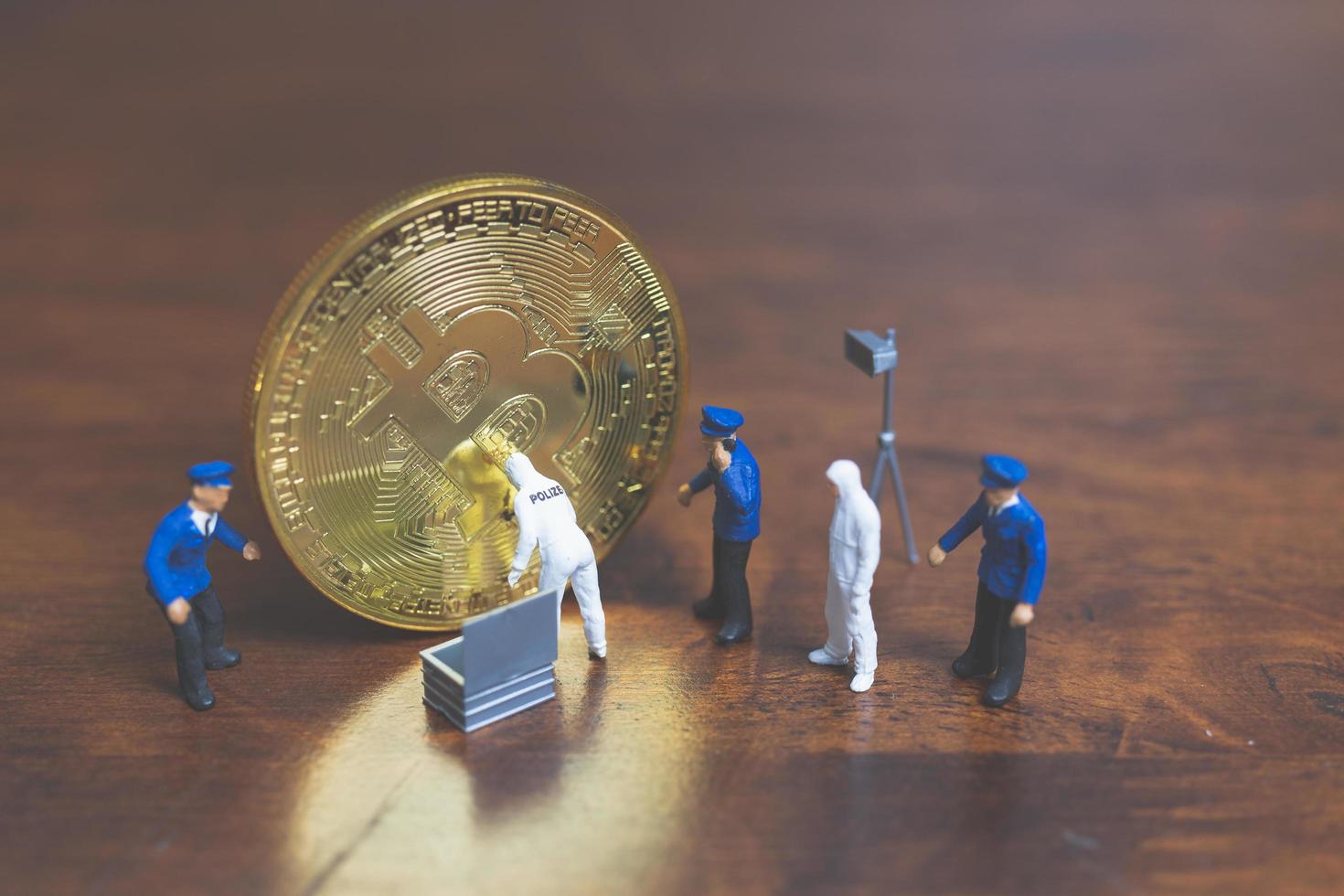 police miniature et détectives debout devant la crypto-monnaie bitcoin, concept de cybercriminalité photo