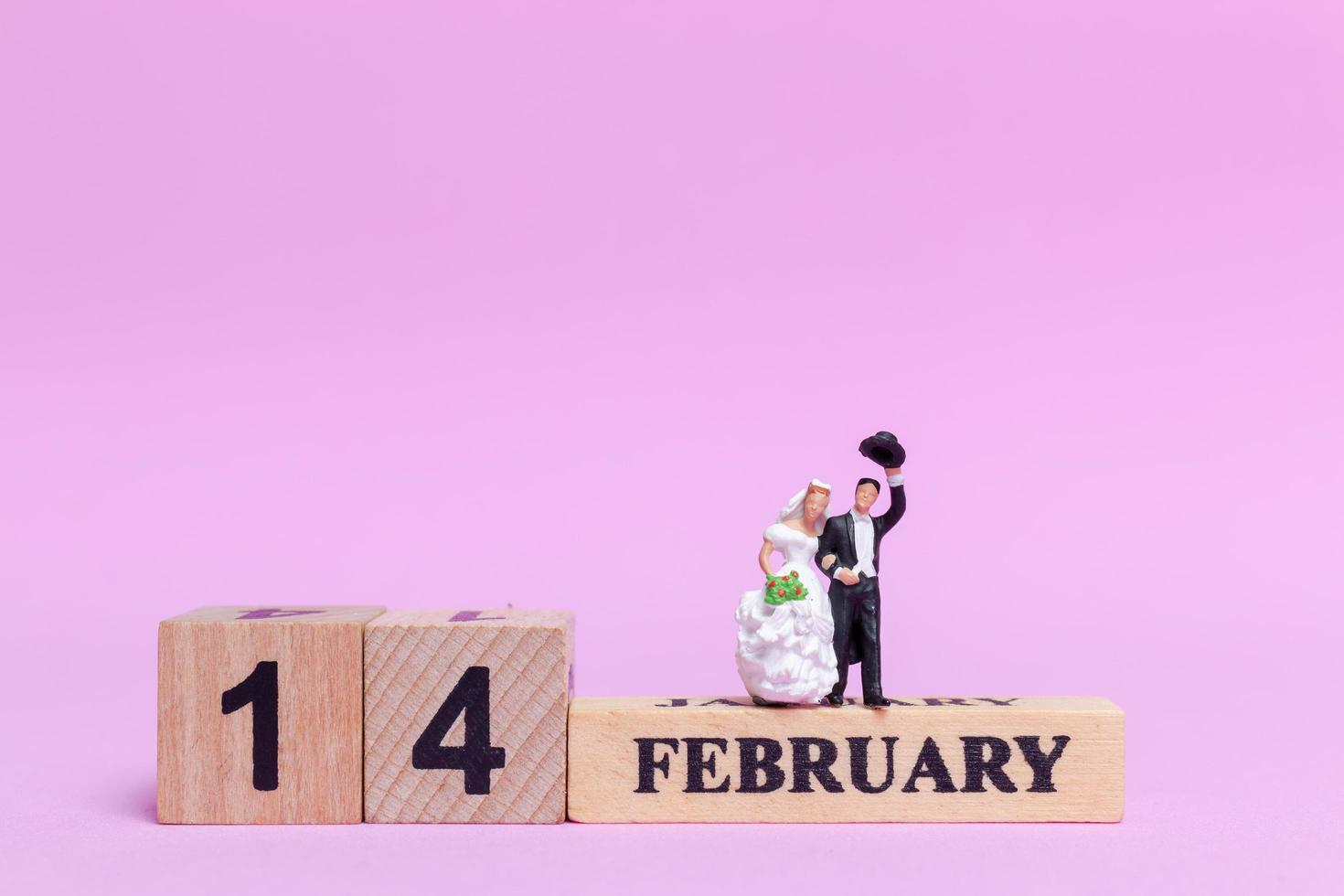 mariée et le marié miniature sur fond rose, la Saint-Valentin et le concept de mariage photo