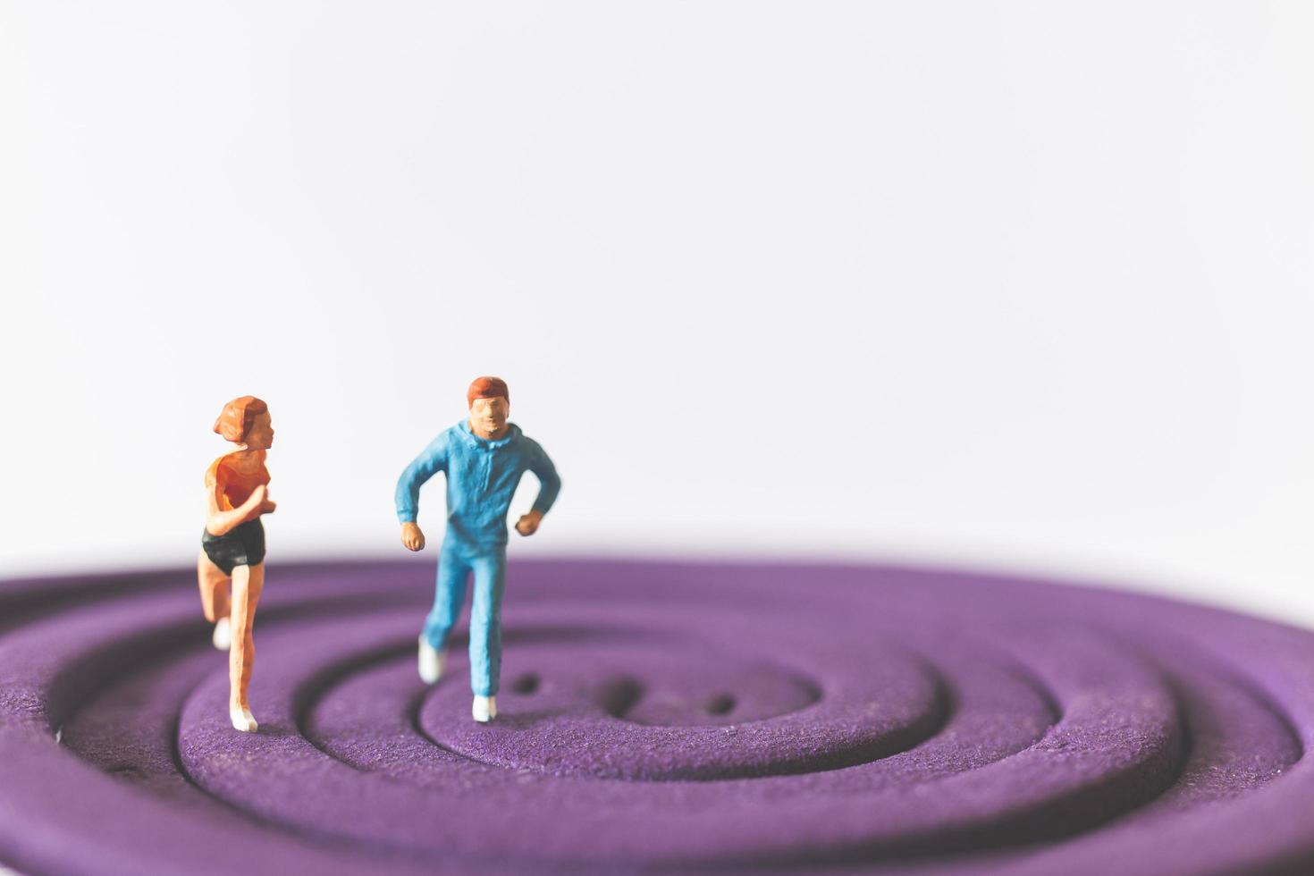 Couple miniature fonctionnant sur un champ circulaire violet photo