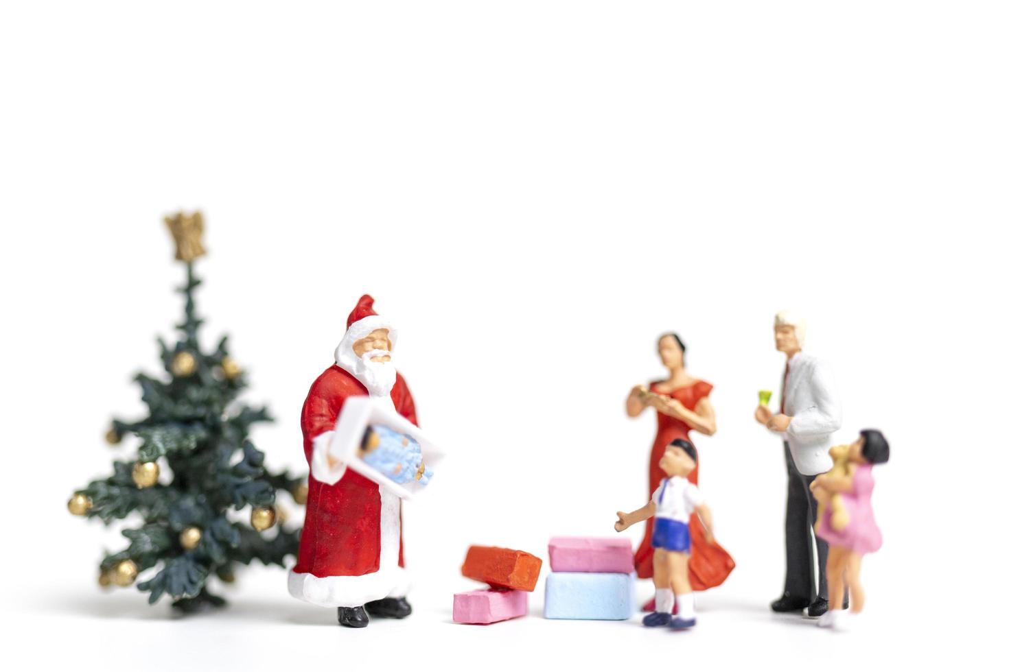 Père Noël miniature tenant des cadeaux pour une famille heureuse, Noël et bonne année concept photo