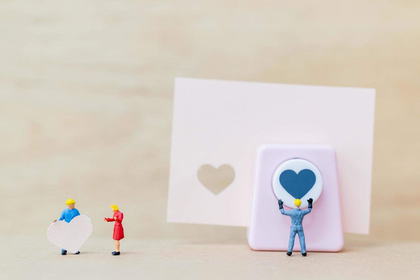 Couple miniature avec un coeur en papier sur fond de bois, concept de la Saint-Valentin photo